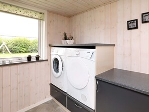 A compact laundry room with a washing machine, a sink, and a window with a view of greenery. - 5 Star Holiday Home in Fjerritslev (Fjerritslev)