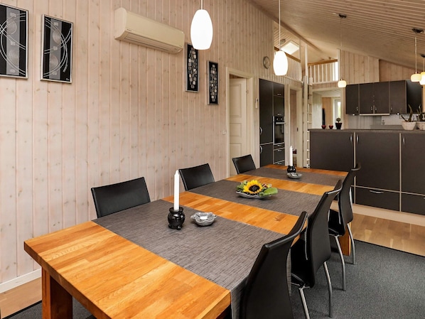 A dining area with a wooden table, black chairs, and a grey placemat.