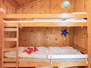 A bunk bed room with a ladder on the left, a star-shaped decoration on the wall, and two stuffed toys on the lower bed. - 6 Person Holiday Home in Gedser (Gedser)