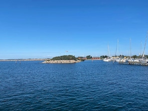 A marina with boats docked, a rocky breakwater, and a clear blue sky. - 6 Person Holiday Home in Gedser (Gedser)