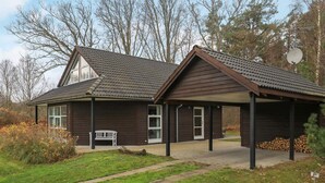 A two-story house with a covered porch and a small garden area. - 4 Star Holiday Home in Laeso (Læsø)