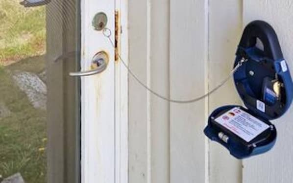A door with a lock, a keyhole, and a padlock attached to the door frame.