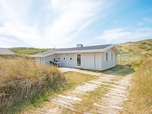 A single-story house with a flat roof, a front door, and a small patio area.