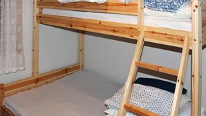 A bunk bed with a wooden ladder, white bedding, and a lace curtain. - 5 Person Holiday Home in Selsoyvik (Rodoy)