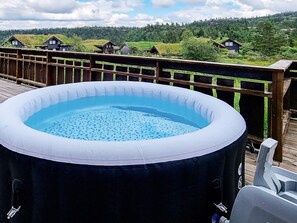 An inflatable pool on a wooden deck with a view of houses and greenery in the background. - 8 Person Holiday Home in Aseral (Aseral)