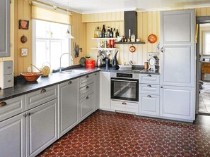 A kitchen with a built-in oven, a sink, and a variety of kitchen utensils and appliances. - 7 Person Holiday Home in Varekil (Varekil)