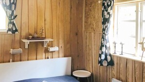 A room with a bed, a small round table, and a radiator. - 6 Person Holiday Home in Savsjo (Savsjo)