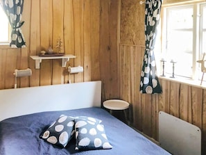 A room with a bed, a small round table, and a radiator. - 6 Person Holiday Home in Savsjo (Savsjo)
