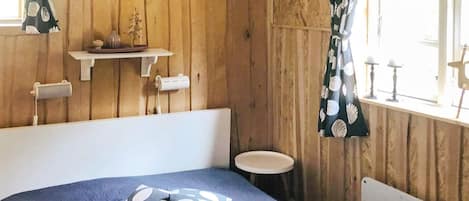 Una habitación con una cama, una mesita redonda y un radiador.