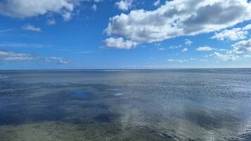 A clear view of a calm sea under a partly cloudy sky.