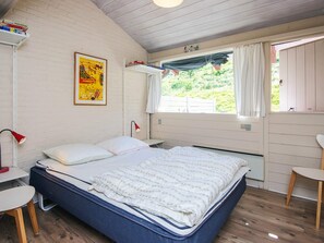 A bedroom with a bed, a desk, a chair, a window with curtains, and a poster on the wall. - 6 Person Holiday Home in Aabenraa (Aabenraa)