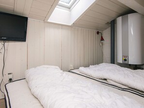 A room with two beds, a television mounted on the wall, and a water heater. - 6 Person Holiday Home in Aabenraa (Aabenraa)