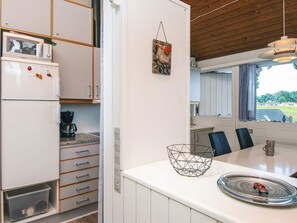 A compact kitchen with a microwave, coffee maker, and a dining area with a table and chairs. - 6 Person Holiday Home in Aabenraa (Aabenraa)
