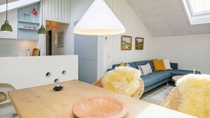 A modern loft apartment with a dining area, a kitchen, and a living room. - 4 Person Holiday Home in Laeso (Læsø)