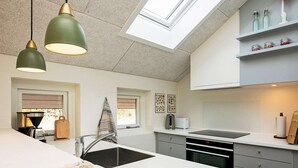 A modern kitchen with a large island, pendant lights, and a skylight. - 4 Person Holiday Home in Laeso (Læsø)