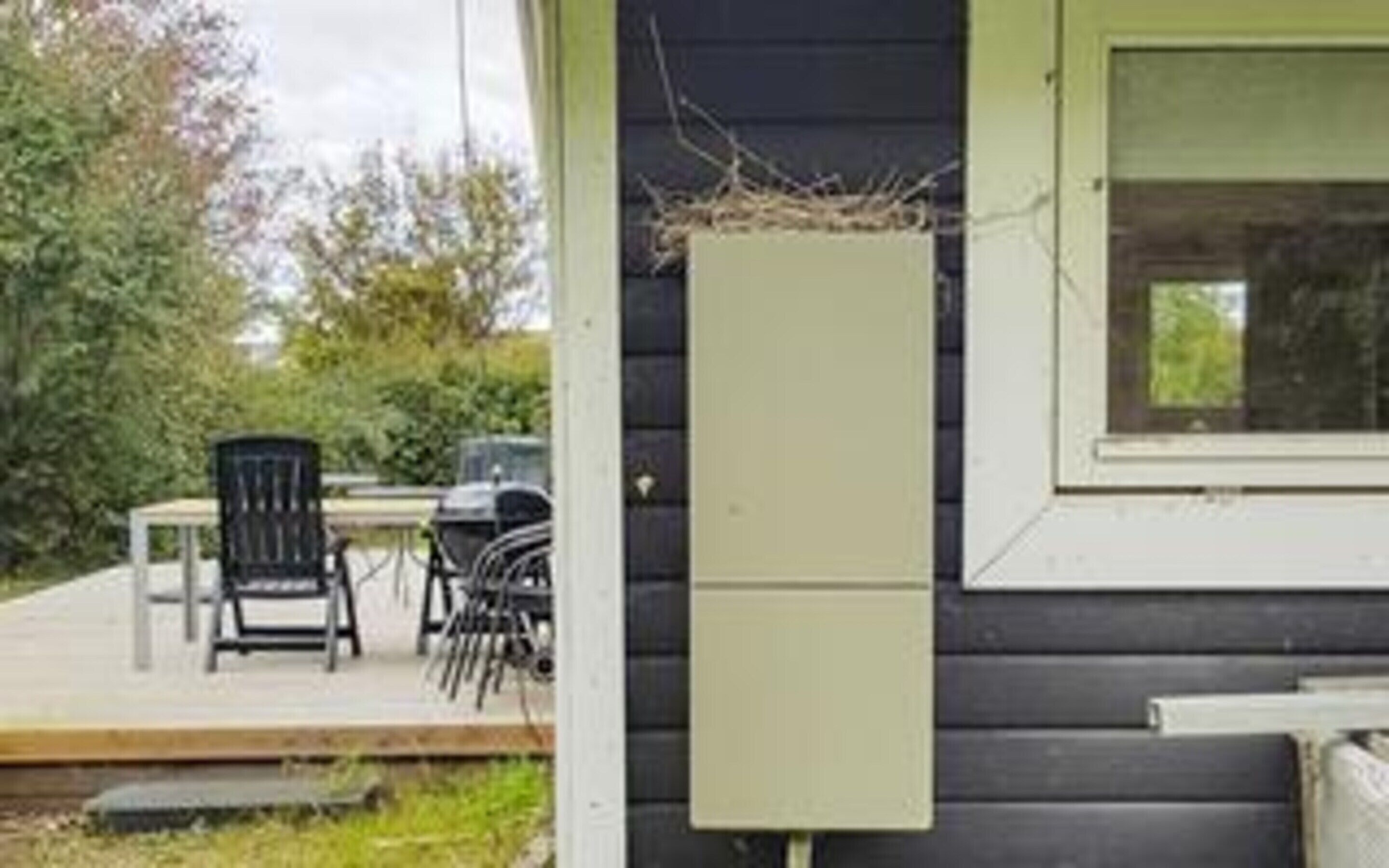 A small building with a porch, a table, and chairs.