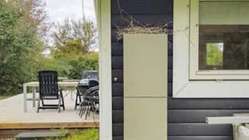 A small building with a porch, a table, and chairs.