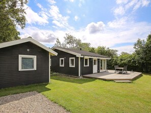 Une maison à deux étages avec un patio couvert et une petite terrasse.