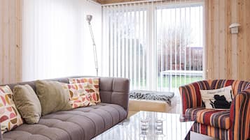 A cozy living room with a sofa, armchair, and glass coffee table.