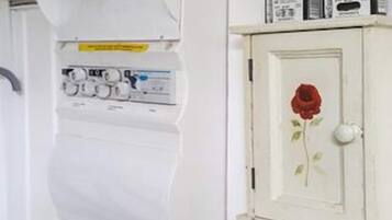 Un mueble blanco con una puerta que tiene una rosa roja.