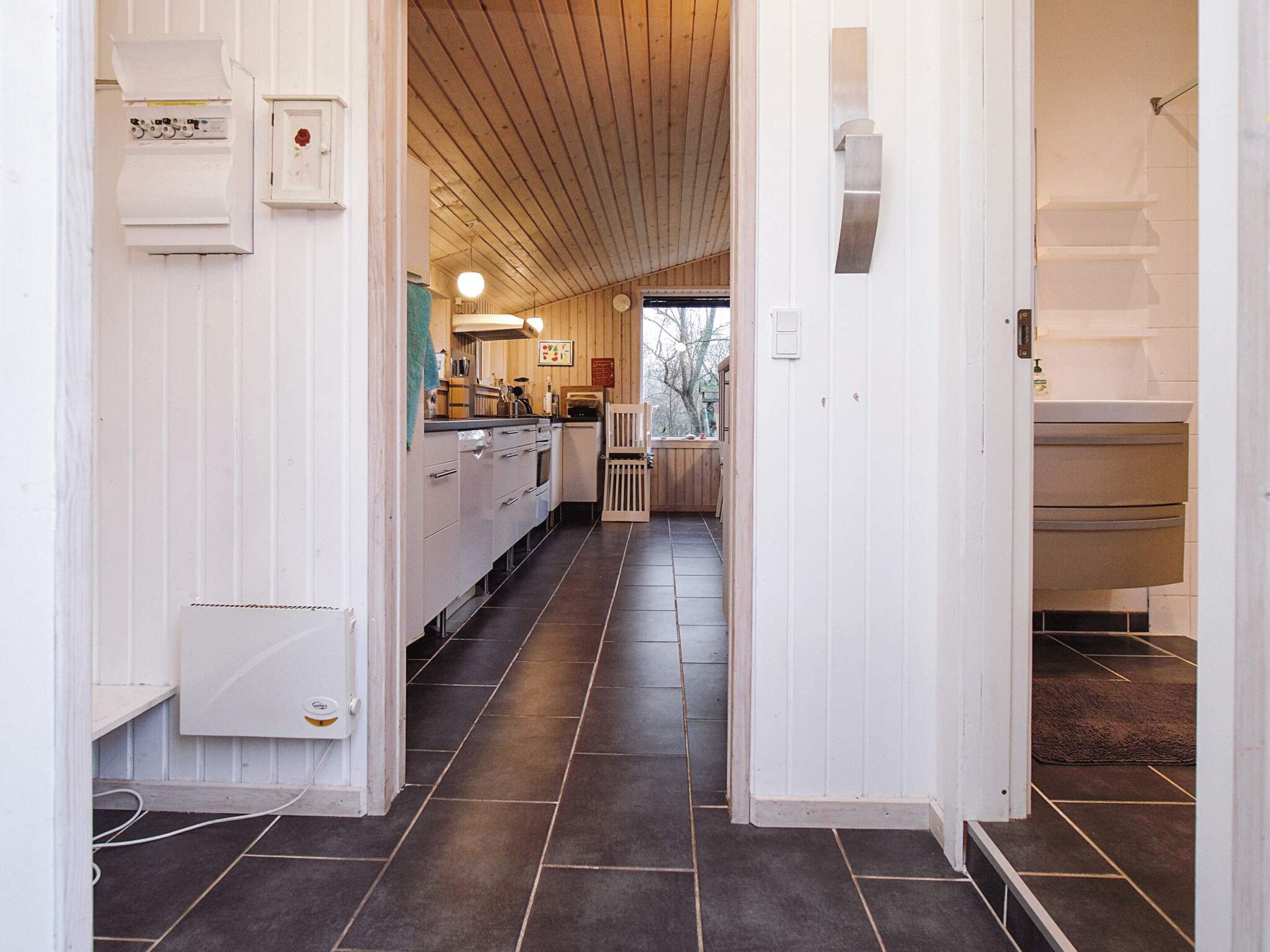 A kitchen with a central island, wooden cabinets, and a view into a dining area.
