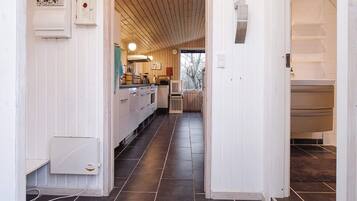 A kitchen with a central island, wooden cabinets, and a view into a dining area.