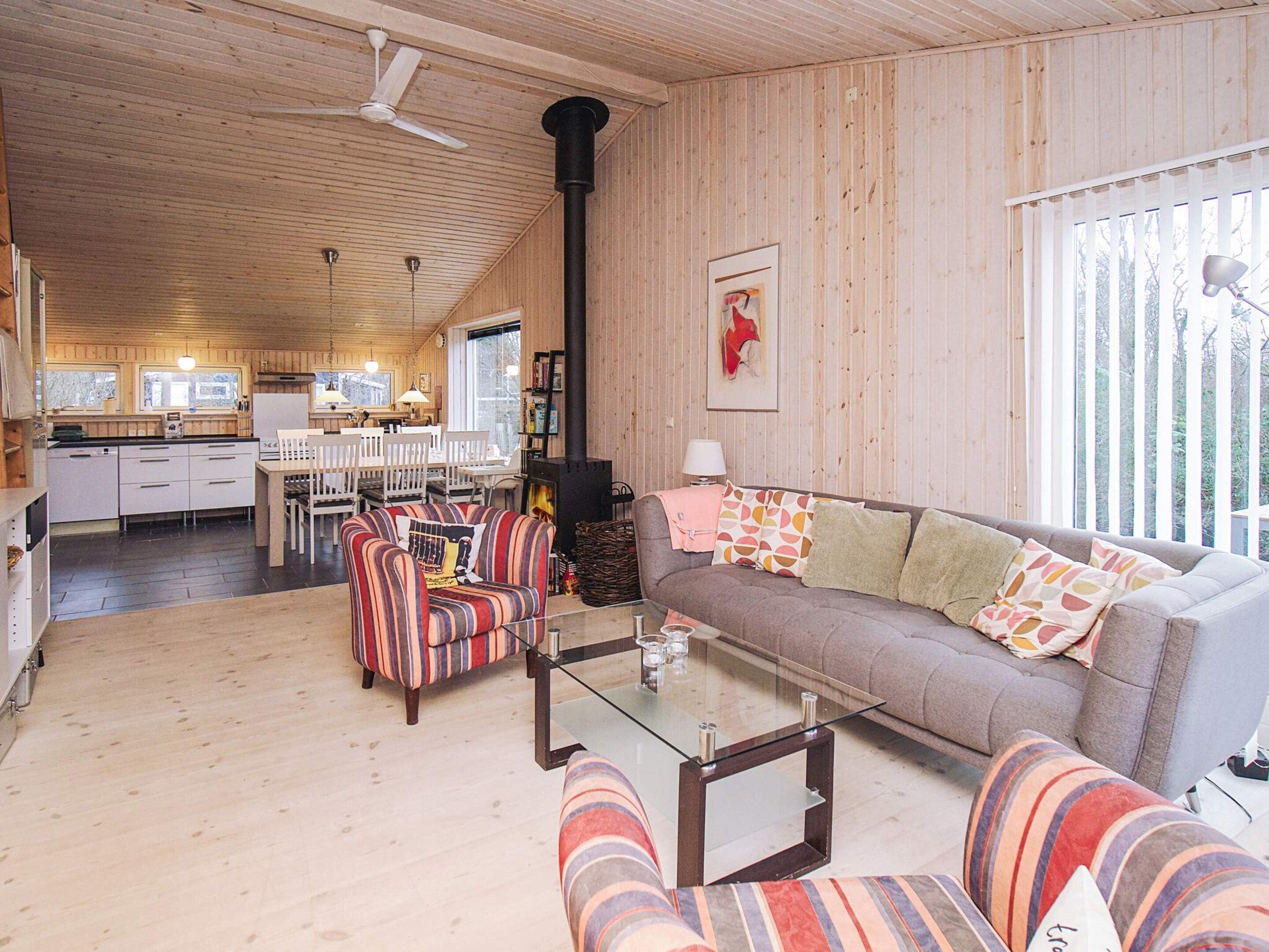 A cozy cabin interior with a dining area, a sofa, and a fireplace.