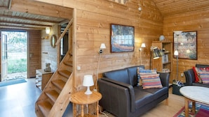 A wooden interior with a staircase, a sofa, a coffee table, and artwork on the walls. - 6 Person Holiday Home in Orsted (Ørsted)