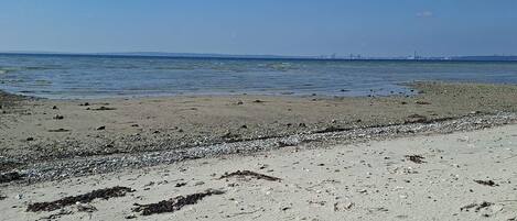 A beach with a rocky shoreline and a clear view of the ocean.