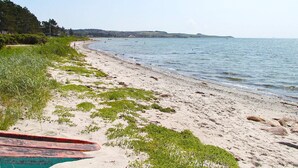 A beach with a sandy shore, a boat, and a calm sea. - 4 Star Holiday Home in Knebel (Knebel)