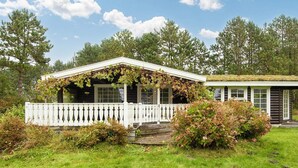 A cabin with a white porch and a covered porch area. - 4 Star Holiday Home in Knebel (Knebel)