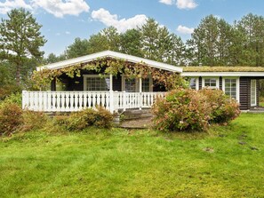 A cabin with a white porch and a covered porch area.