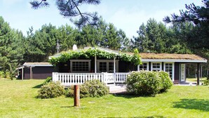 A house with a porch, a small garden, and a shed in the background. - 4 Star Holiday Home in Knebel (Knebel)