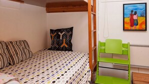 A small, cozy room with a bunk bed, a green chair, a patterned pillow, and a painting on the wall. - Tranquil Holiday Home in Ebeltoft near Sea (Ebeltoft)