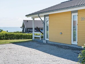 Un bâtiment à la façade jaune, avec une porte blanche et le numéro 28.