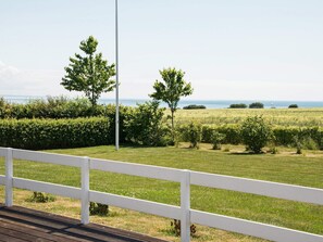 A view of a grassy field with a white fence in the foreground and a clear sky. - 5 Star Holiday Home in Sydals (Sydals)