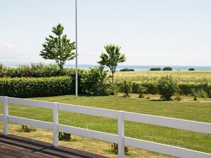 A view of a grassy field with a white fence in the foreground and a clear sky. - 5 Star Holiday Home in Sydals (Sydals)