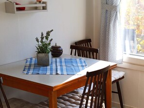 A dining table with a blue checkered placemat, a potted plant, and a decorative vase. - 2 Person Holiday Home in Falkenberg (Falkenberg)