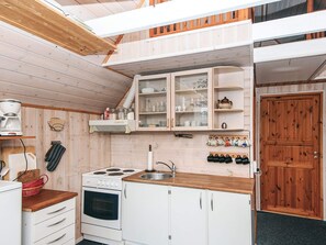 A compact kitchen with white cabinetry, a stove, and a sink. - 5 Person Holiday Home in Grindsted (Grindsted)