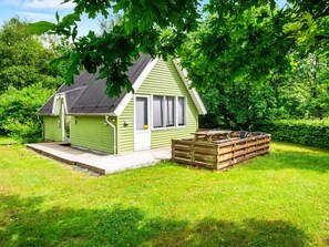 A small, single-story house with a sloped roof, a front porch, and a wooden deck. - 5 Person Holiday Home in Grindsted (Grindsted)