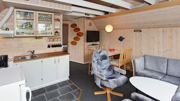 Un espacio habitable compacto con kitchenette, comedor y asientos.