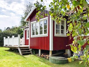 A red building with a white porch and steps leading up to it.