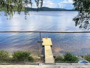 A wooden dock extending into a calm lake with a clear view of the surrounding landscape. - 4 Person Holiday Home in Bullaren (Bullaren)