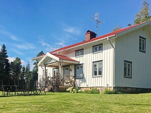 A single-story house with a red roof, a chimney, and a porch with a railing. - Holiday Home in Håcksvik (Sandared)