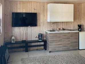 A compact kitchen with a built-in TV, a sink, and a coffee maker. - 5 Star Holiday Home in Urangsvag (Bomlo)
