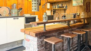 A rustic kitchen with a wooden bar area, a vintage toaster, and a hanging lantern. - 5 Person Holiday Home in Varekil (Varekil)