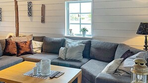 A cozy living room with a sectional sofa, a wooden coffee table, and a vintage lantern. - 5 Person Holiday Home in Varekil (Varekil)