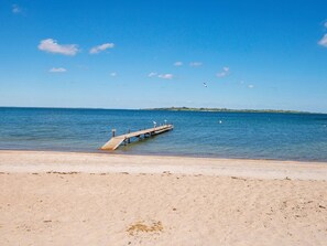A beach with a wooden pier extending into calm blue waters. - 4 Star Holiday Home in Aabenraa (Aabenraa)