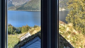 Une vue sur un lac, avec des montagnes en arrière-plan, visible à travers les cadres des fenêtres.