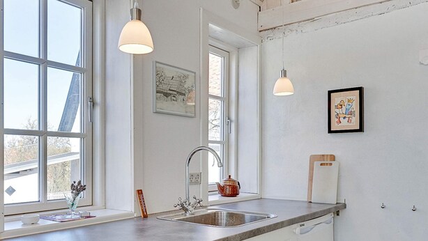 A kitchen with a large window, a sink, and two pendant lights. - Vintage Holiday Home in Svaneke near Small Harbor (Svaneke)